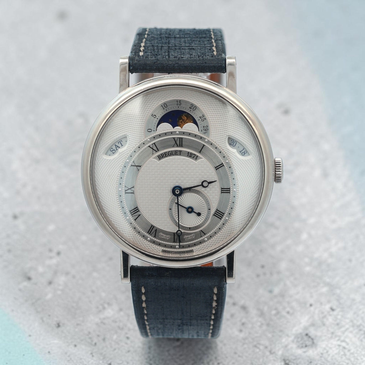 Breguet Classique Calendrier 7337 with a textured dial, blue open-tipped hands, Roman numerals and a moon-phase display